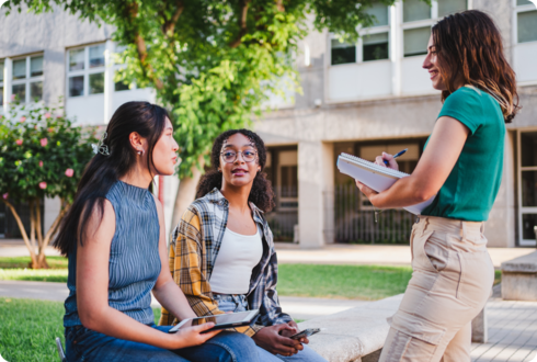 Studieren mit MS Drei junge Frauen befinden sich vor einem Gebäude und unterhalten sich.