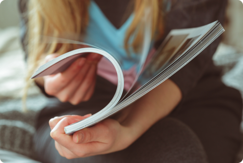 Eine Frau blättert in einem Magazin.