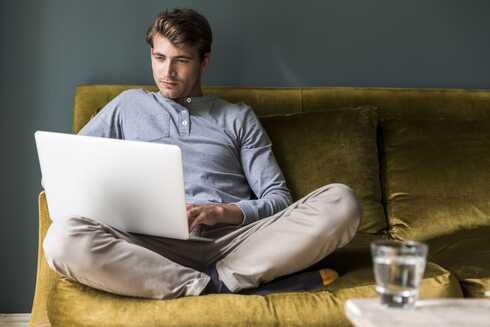 Mann schaut auf seinen Laptop