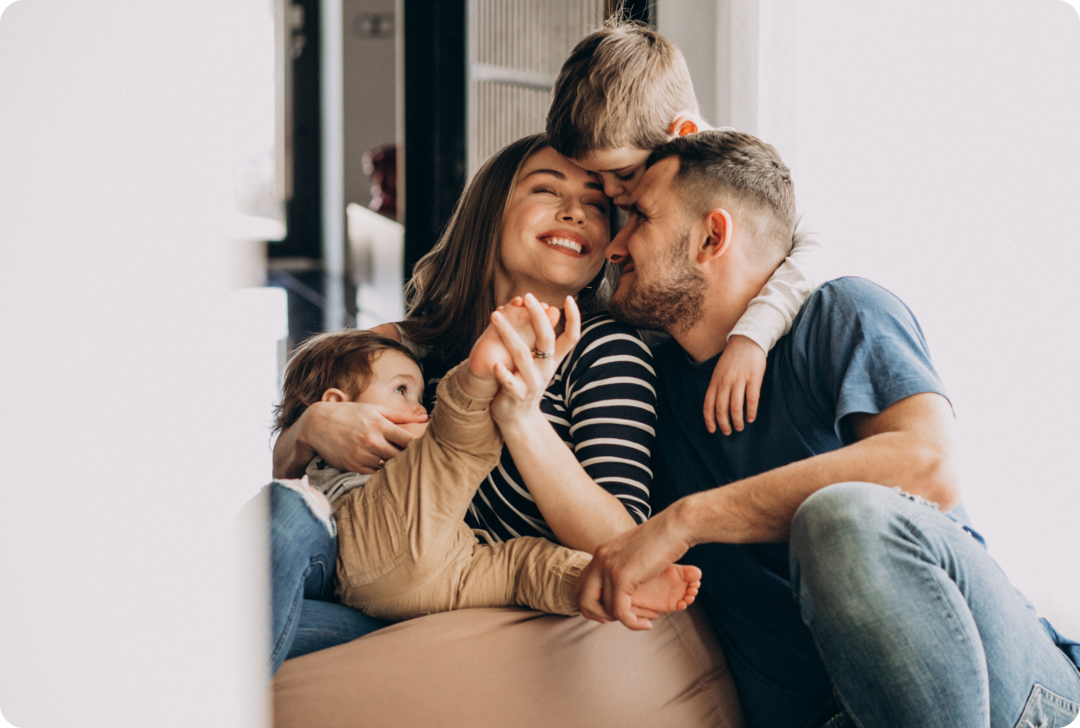 Eine Frau, ein Mann und zwei Kinder umarmen sich.