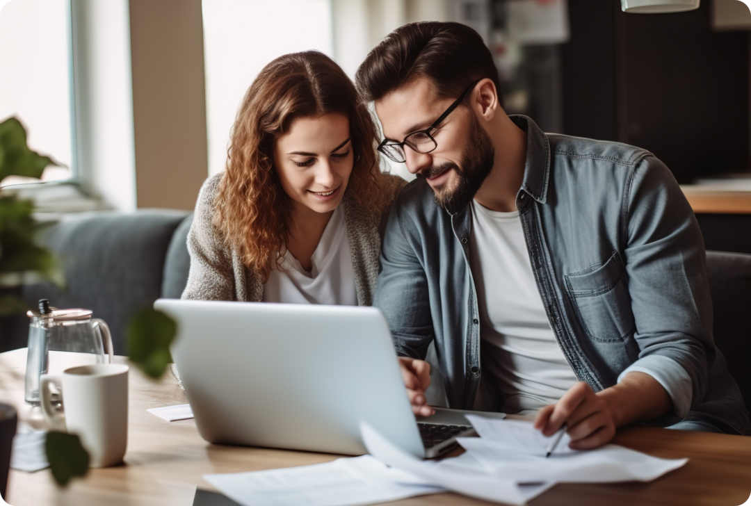 Ein Mann und eine Frau sitzen vor einem Laptop. 