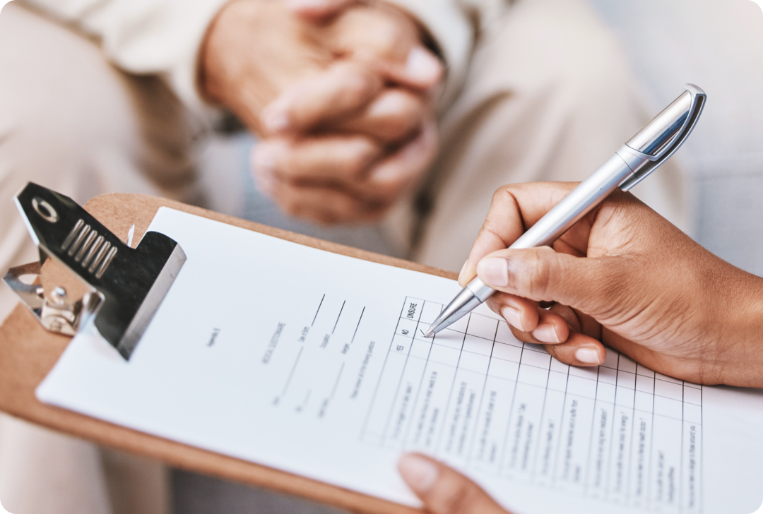 Ein Mensch hält ein Klemmbrett und einen Stift.