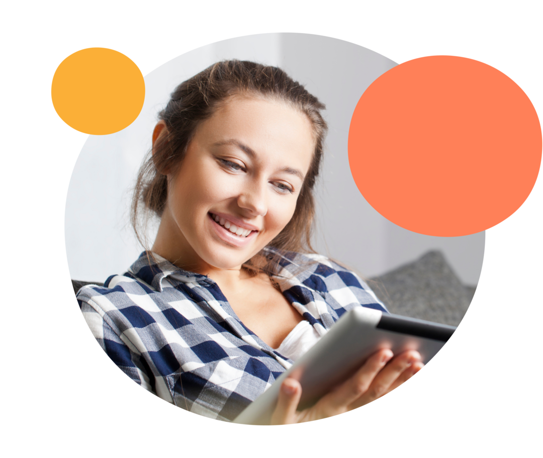 Eine Frau schaut auf ihr Tablet und lächelt.