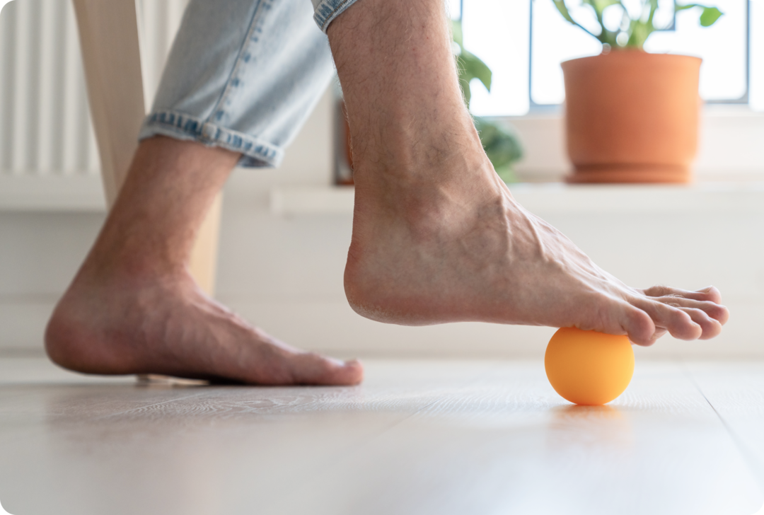Nahaufnahme eines Fußes, der auf einem kleinen Ball abliegt. 