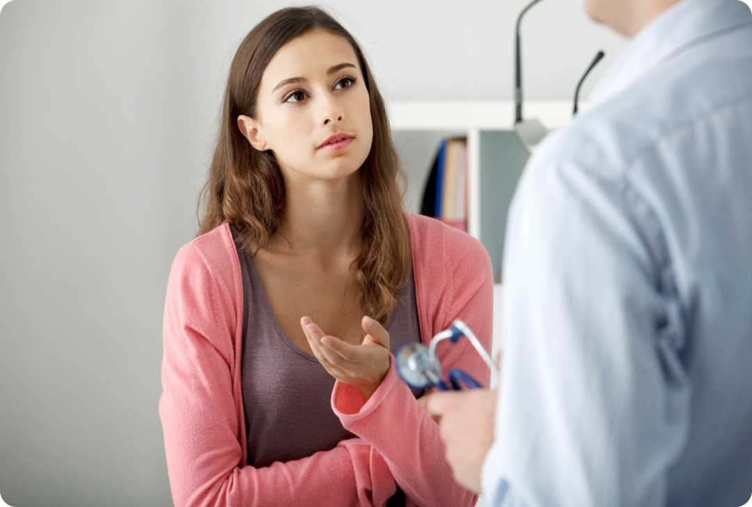 Eine Frau spricht mit einem Mann, der ein Stethoskop in den Händen hält.