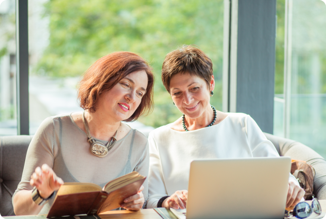 Überblick über die MS-Behandlung Zwei Frauen schauen auf einen Laptop.