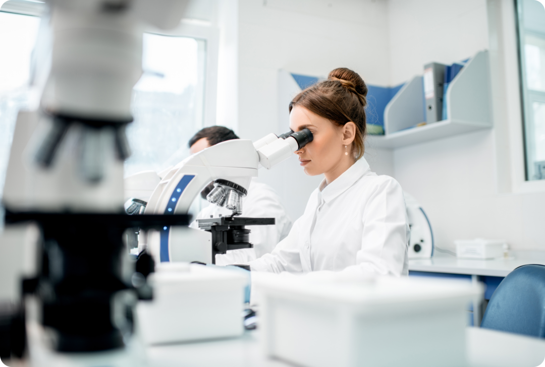 Eine Frau schaut in ein Mikroskop.