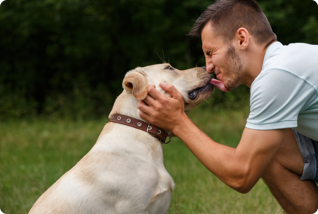 Tiertherapie bei MS Ein Hund leckt über den Mund eines Mannes.