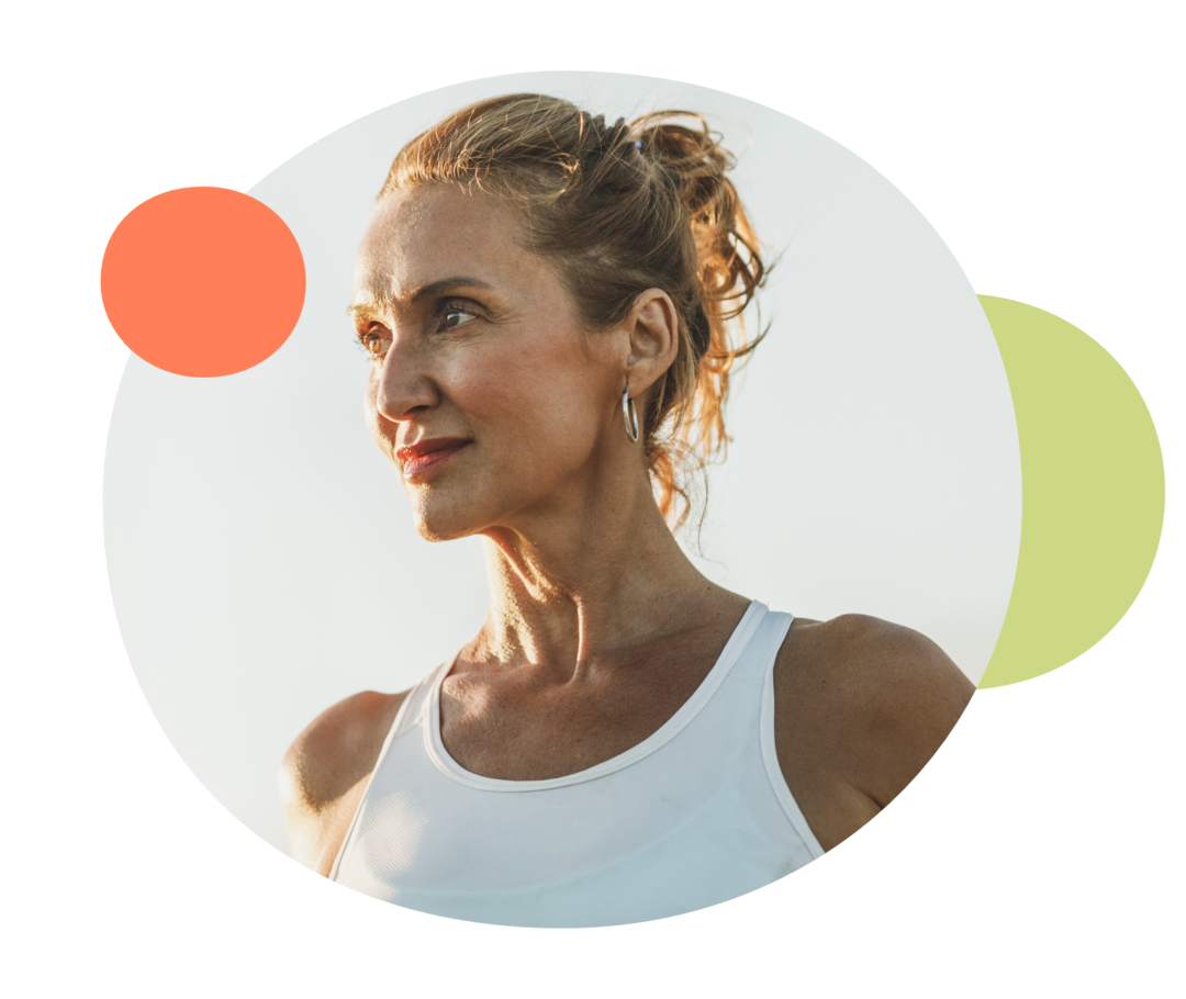 Ein Frau mit hochgesteckten Haaren und Sporthemd schaut nach links.