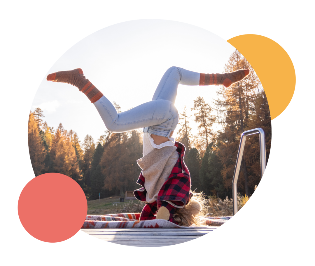 Eine Frau beim Yoga-Kopfstand im Sonnenaufgang.