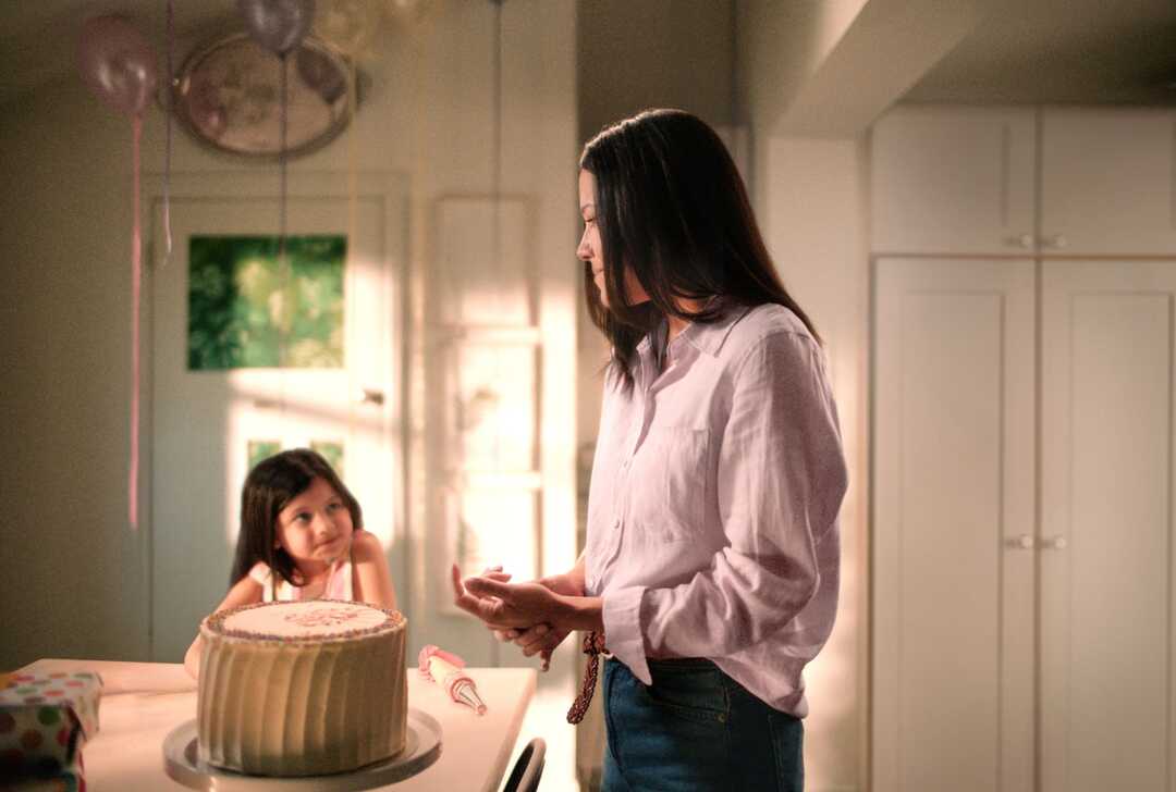 Mutter mit Tochter an einem Tisch mit einer großen Torte